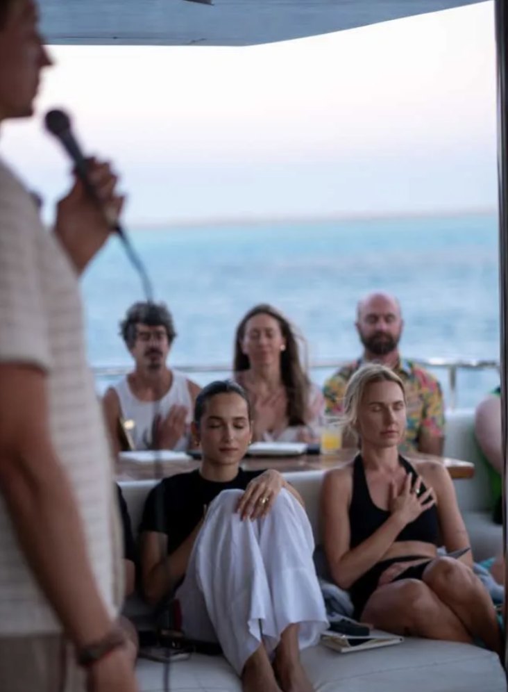 Hands on hearts during a guided breathwork session at sunset